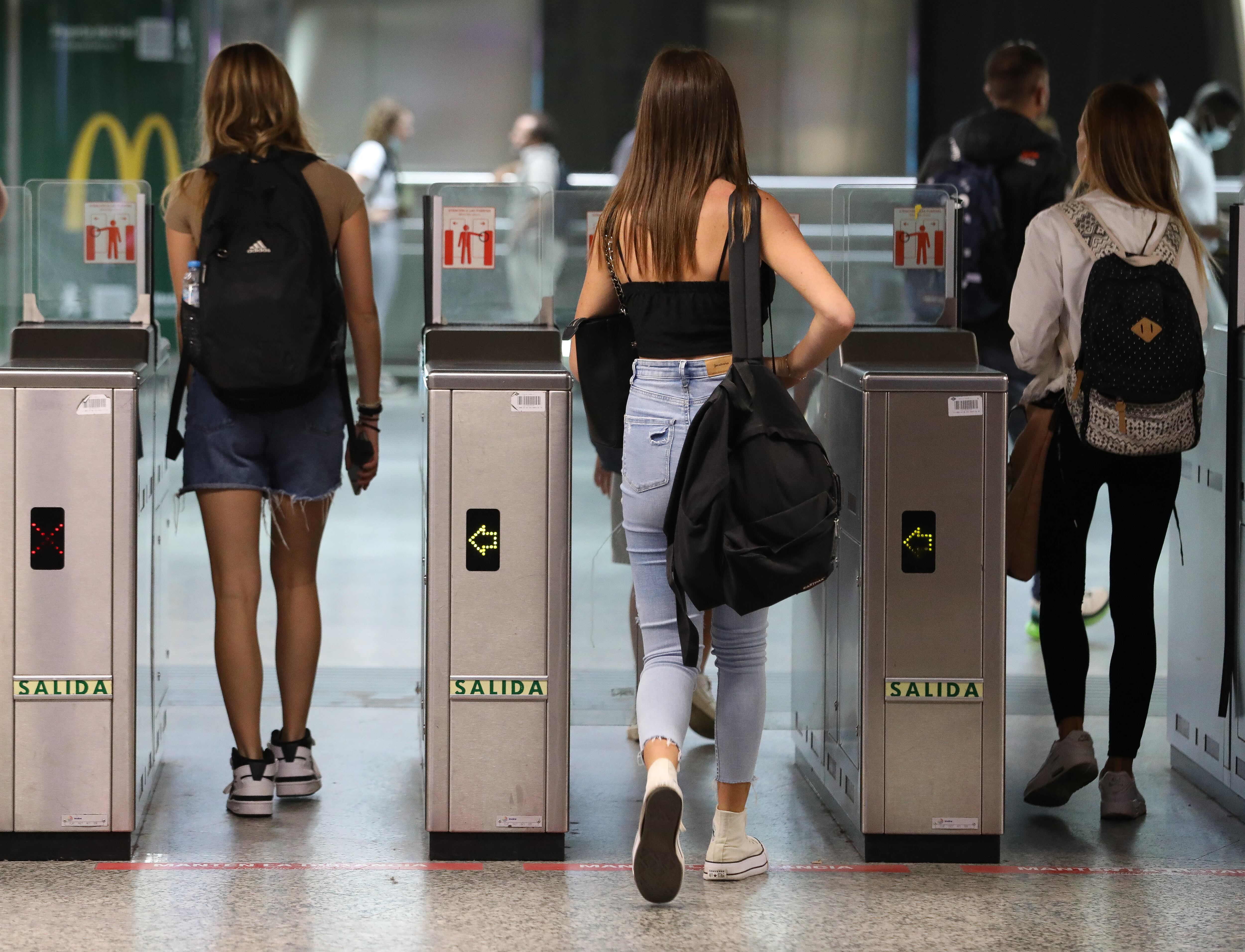 Varias personas pasan los tornos de acceso al Cercanías en la estación de Sol (Madrid).