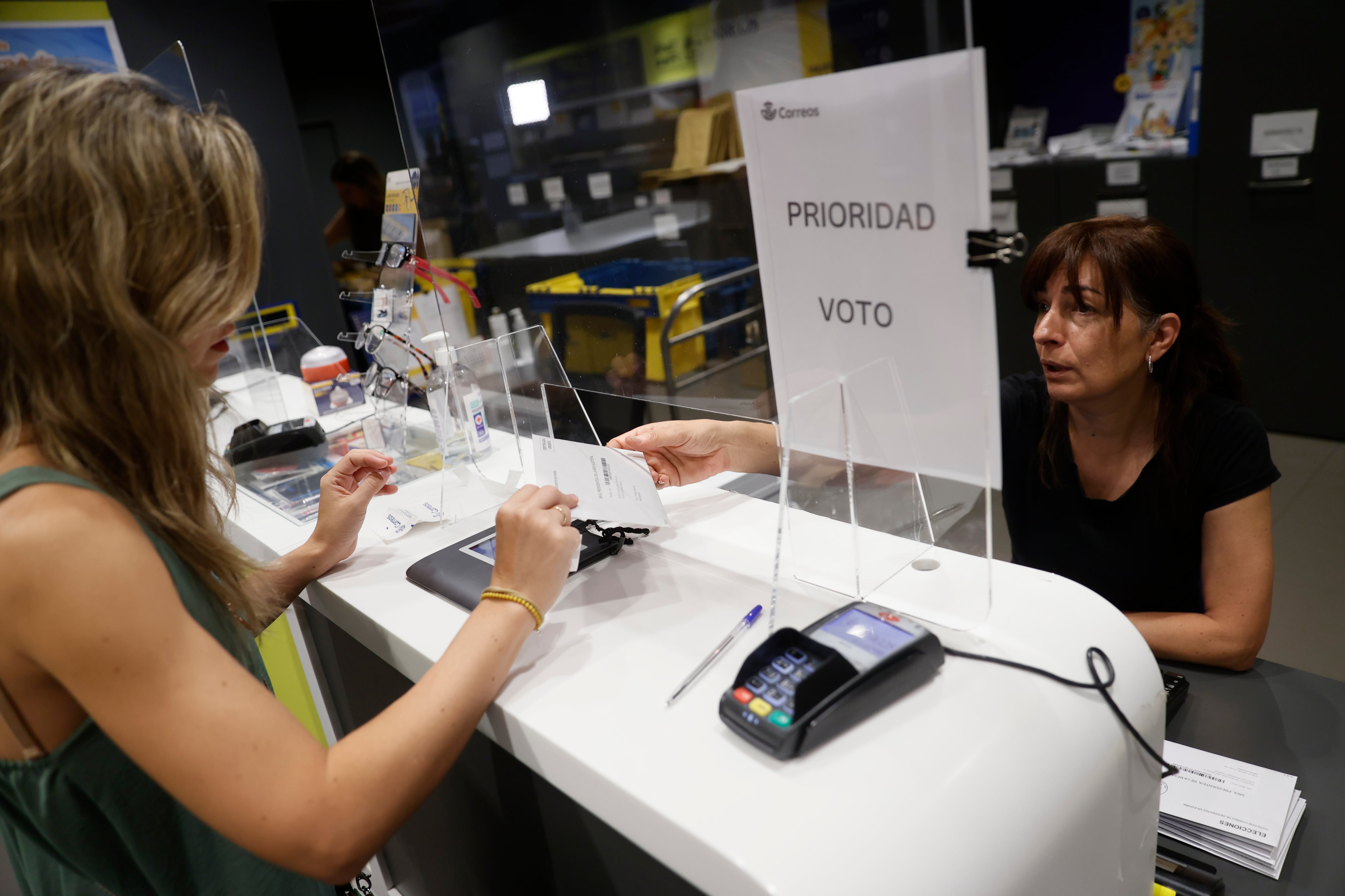 MADRID, 16/07/2023.- Una mujer entrega la documentación para ejercer el voto por correo en una oficina de Madrid. Oficinas de Correos de grandes ciudades y zonas turísticas abren este fin de semana de forma extraordinaria para facilitar el voto por correo. EFE/ Mariscal
