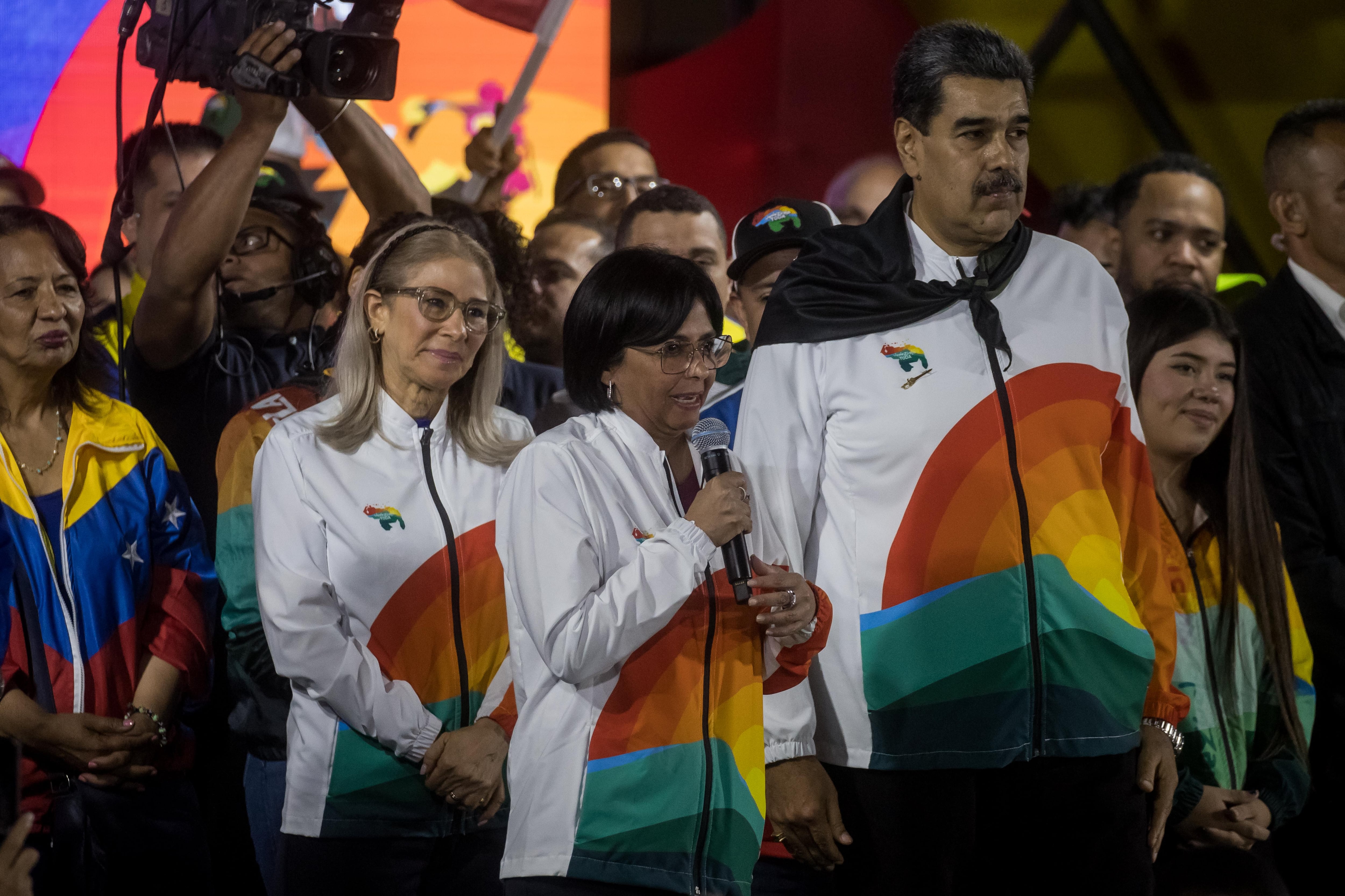 La vicepresidenta, Delcy Rodríguez, habla junto al presidente de Venezuela, Nicolás Maduro (d), y la primera dama, Cilla Flores (i), durante un acto de celebración tras el referéndum consultivo por El Esequibo, en Caracas (Venezuela). Maduro anunció este domingo una nueva y &quot;poderosa&quot; etapa en la disputa territorial con Guyana, luego de conocerse los resultados del referendo no vinculante celebrado en el país, en el que la gran mayoría de electores respaldaron la propuesta de anexionar la zona bajo pleito al mapa nacional.