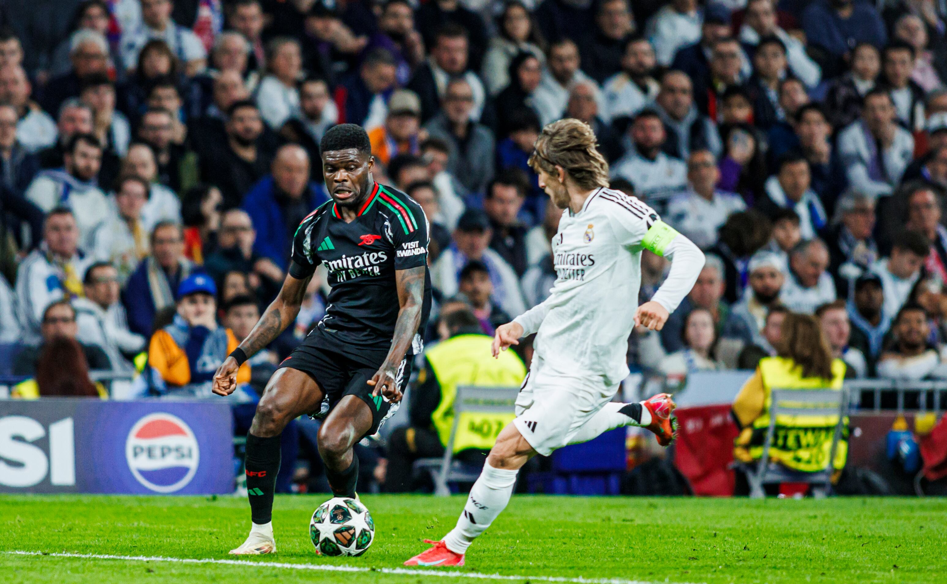 MADRID, SPAIN - APRIL 16: Thomas Partey of Arsenal FC (L) battles for the ball with Luka Modric of Real Madrid CF (R) during the UEFA Champions League 2024/25 Quarter Final Second Leg match between Real Madrid C.F. and Arsenal FC at Estadio Santiago Bernabeu on April 16, 2025 in Madrid, Spain. (Photo by MB Media/Getty Images)