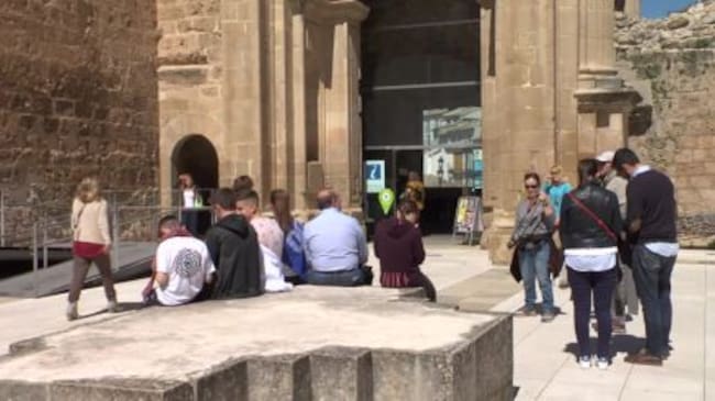 Turistas en las ruinas de la Plaza de Santa María junto a la oficina municipal de turismo