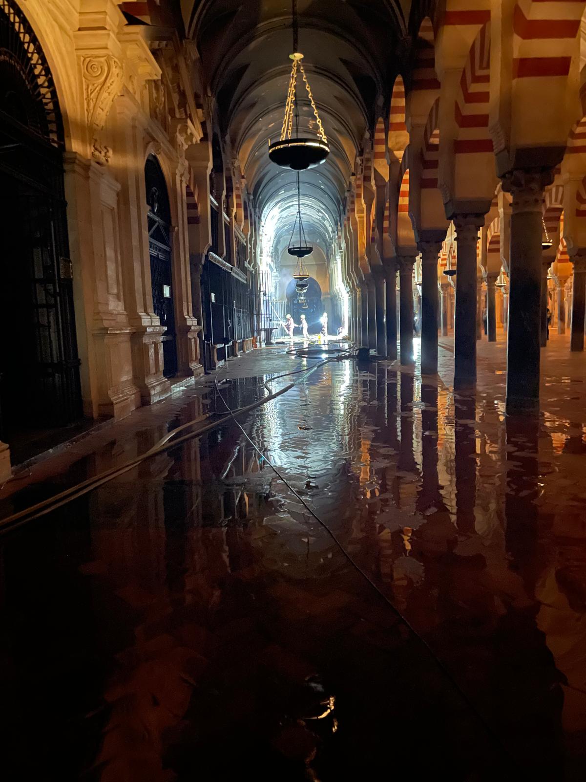 Los bomberos trabajando en el interior de la Mezquita de Córdoba tras el incendio declarado este viernes