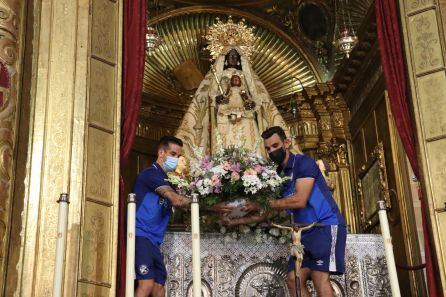 Bello y Camacho depositando las flores a los pies de la patrona