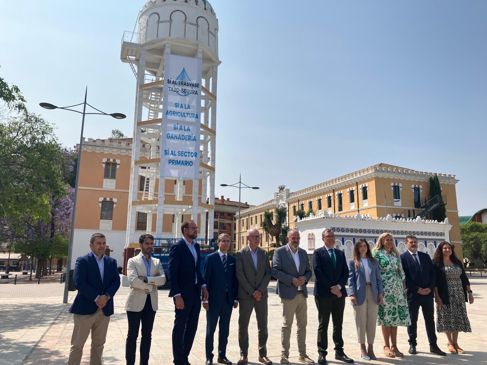 El alcalde de Murcia, José Ballesta, el presidente del SCRATS y varios concejales de Murcia posan en foto de familia. El depósito de agua del Cuartel de Artillería cuenta con una pancarta en defensa del trasvase.