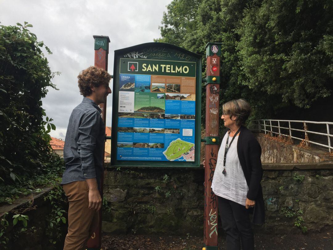 Jon Insausti, concejal delegado de cultura del ayuntamiento de San Sebastián junto a Susana Soto, directora del Museo San Telmo junto al cartel que contiene el recorrido por Urgull.