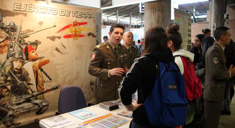 Un militar parlant amb dues joves en l'última edició d'Expojove.