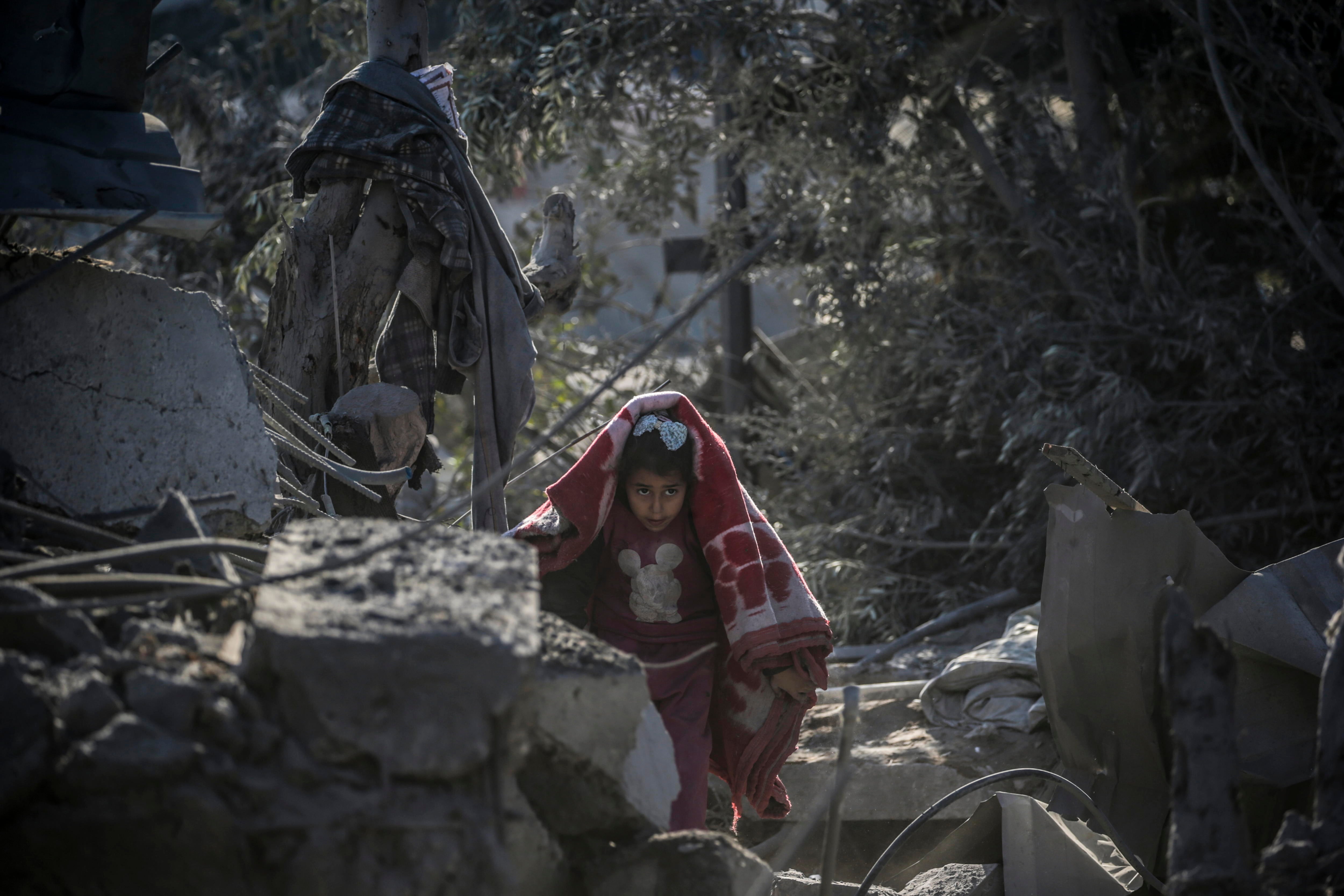 Una niña palestina inspecciona la casa destruida de su familia tras un ataque aéreo israelí en el campamento de refugiados de Al Maghazi, en el centro de la Franja de Gaza