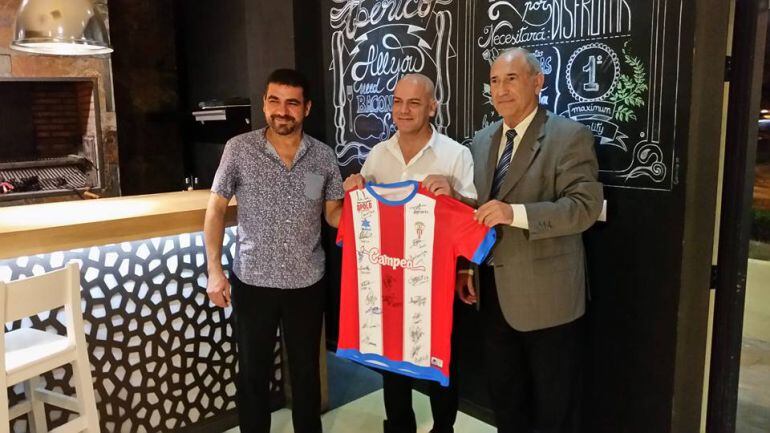 Ricardo Alfonso Álvarez entrega una camiseta al dueño del restaurante.