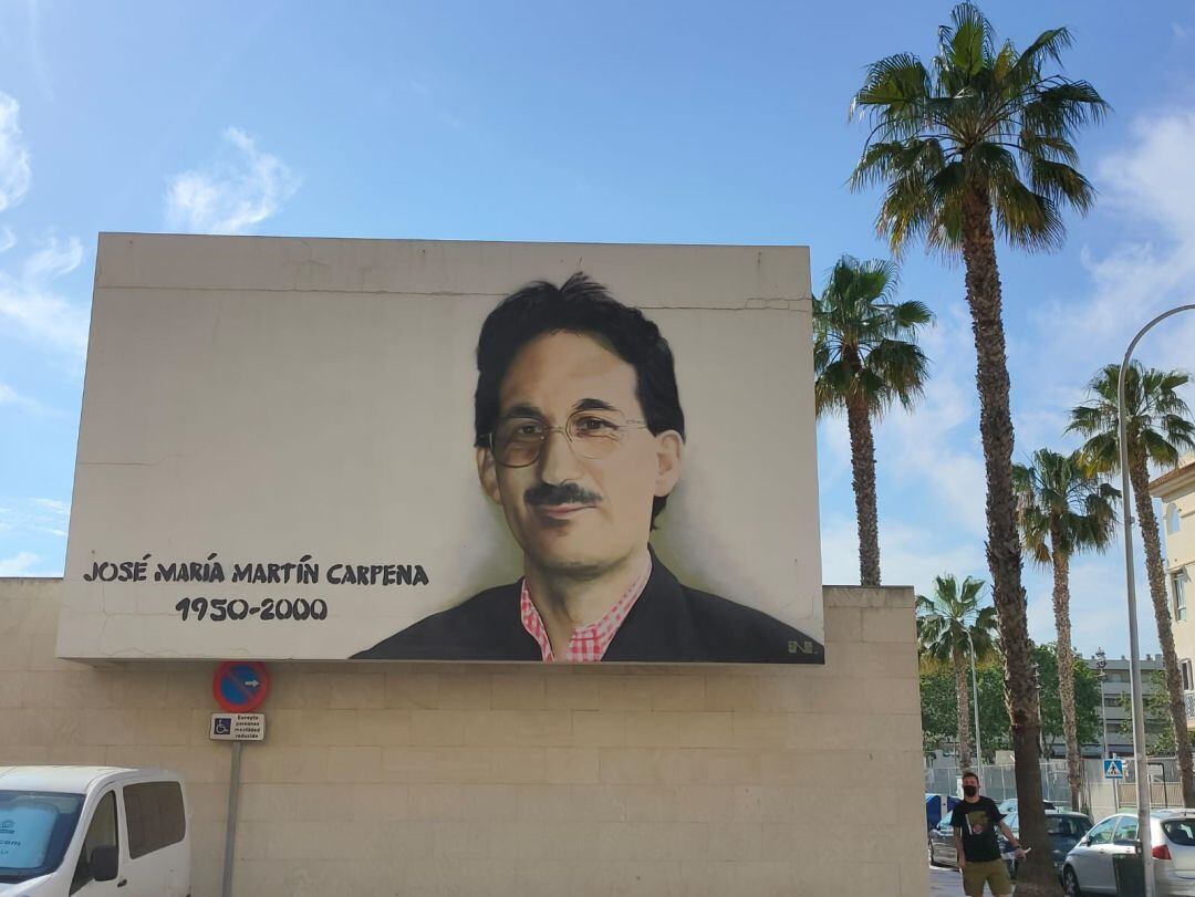 El artista urbano Nesui al fondo al finalizar el mural