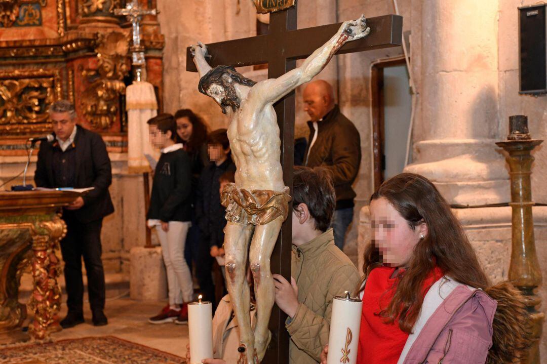 El alcalde de San Miguel de Bernuy (Segovia), José María Bravo (i), ha ejercido hoy como celebrador de la palabra, ante la ausencia de sacerdotes, dirigiendo el viacrucis en su localidad, que se ha desarrollado en el interior de la iglesia, debido a la lluvia, con la participación de los más jóvenes que han portado una talla de Cristo crucificado, del siglo XVIII. 