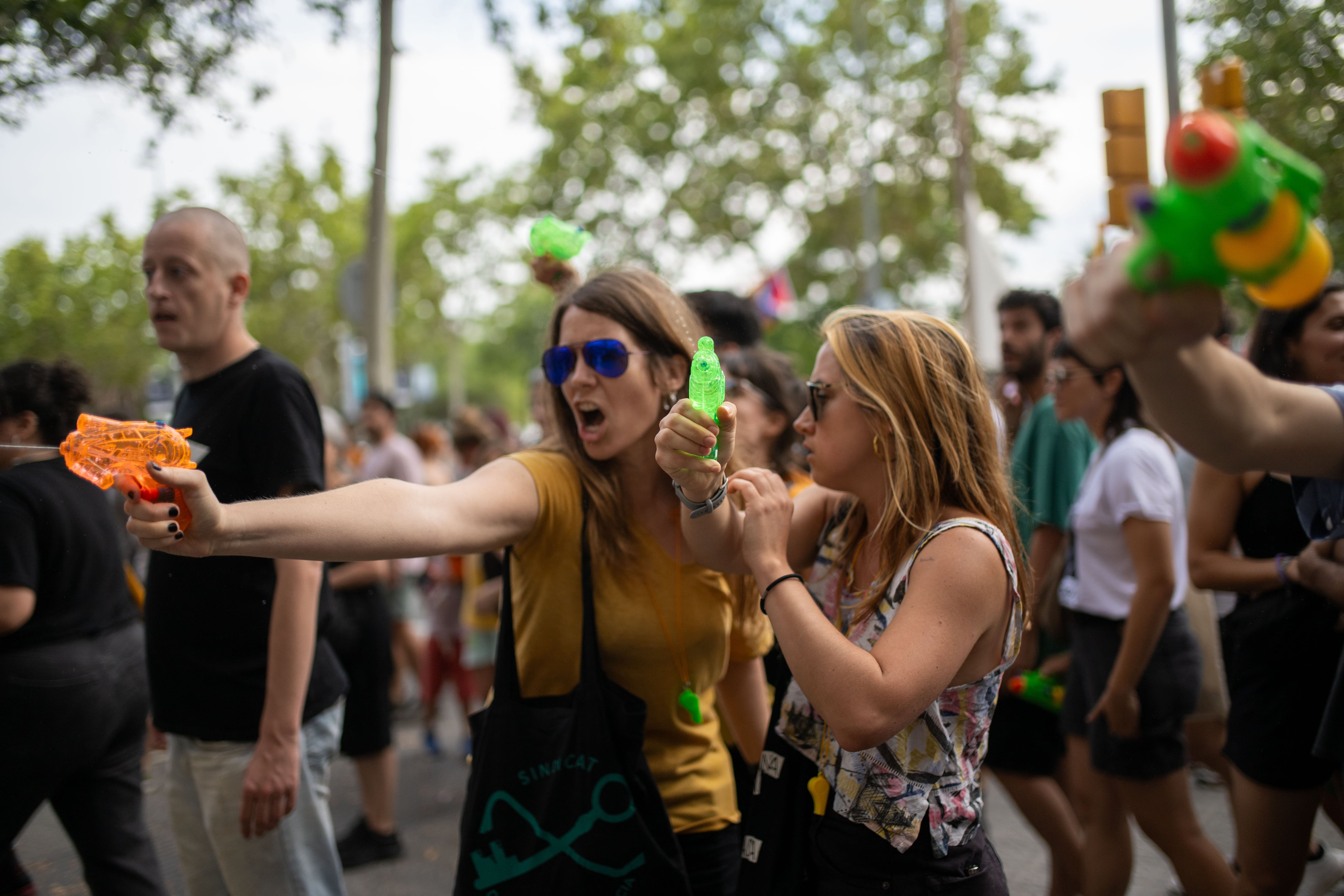 Dos mujeres rocían con agua a los turistas durante la manifestación de Barcelona.