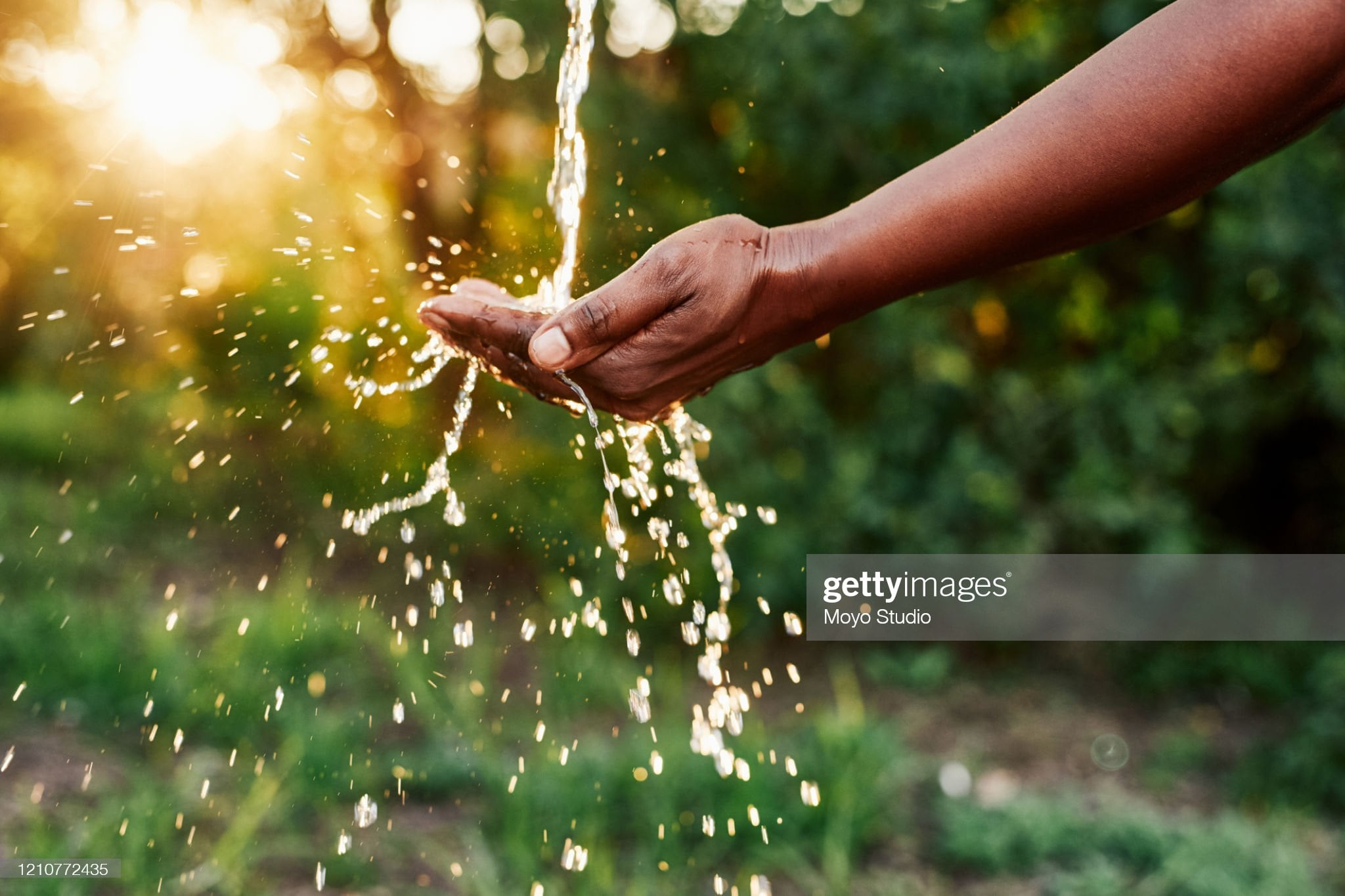 Cropped shot of an unrecognizable woman’s hands under a stream of running water outdoors