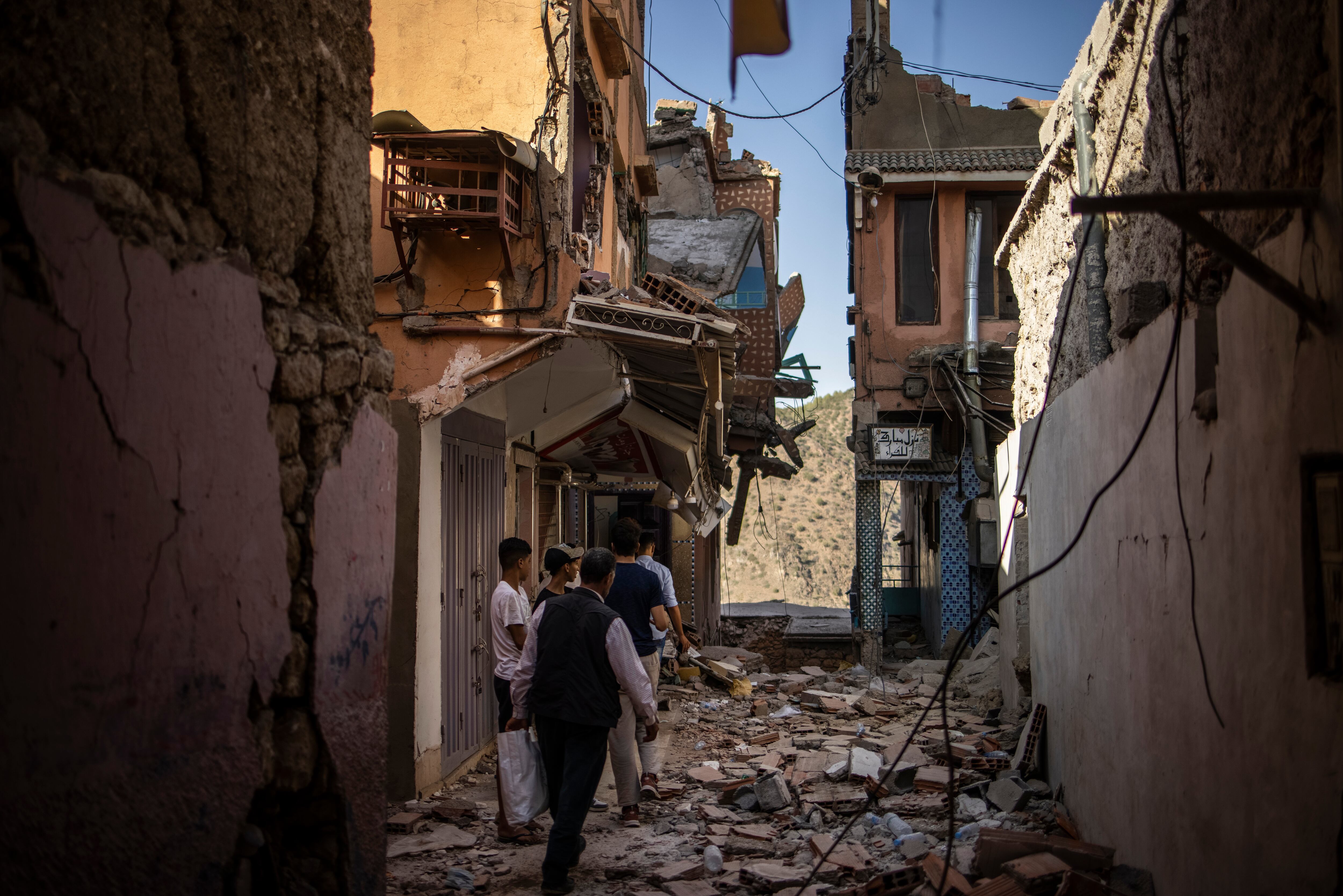 Moulay Brahim (Morocco), 11/09/2023.- People walk between damaged buildings following a powerful earthquake, in Moulay Brahim, south of Marrakesh, Morocco, 11 September 2023. The magnitude 6.8 earthquake that struck central Morocco late 08 September has killed more than 2,450 people and injured around 2,500 others, damaging buildings from villages and towns in the Atlas Mountains to Marrakesh, according to a report released by the country's Interior Ministry. The earthquake has affected more than 300,000 people in Marrakesh and its outskirts, the UN Office for the Coordination of Humanitarian Affairs (OCHA) said. Morocco's King Mohammed VI on 09 September declared a three-day national mourning for the victims of the earthquake. (Terremoto/sismo, Marruecos) EFE/EPA/YOAN VALAT