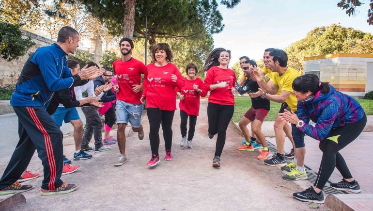 Varios corredores jalean a algunos voluntarios que harán posible que se desarrolle el Maratón de Valencia