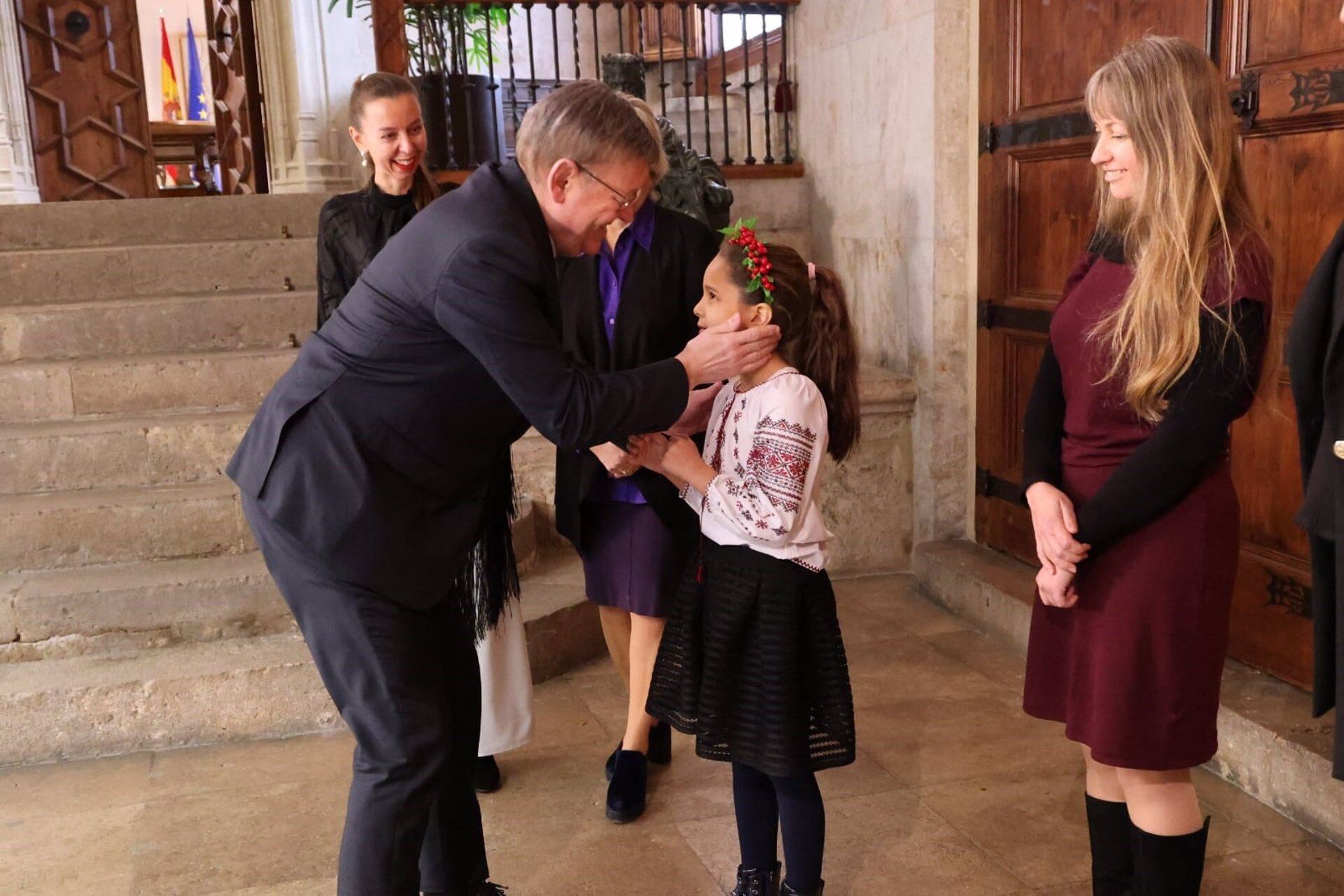 El president de la Generalitat, Ximo Puig, acaricia a Marisa, una niña ucraniana de 7 años. Fuente: GVA