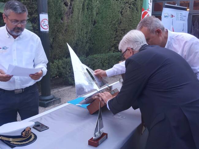 Miguel Baena coloca la placa del velero ganador de la anterior regata el Tanit IV