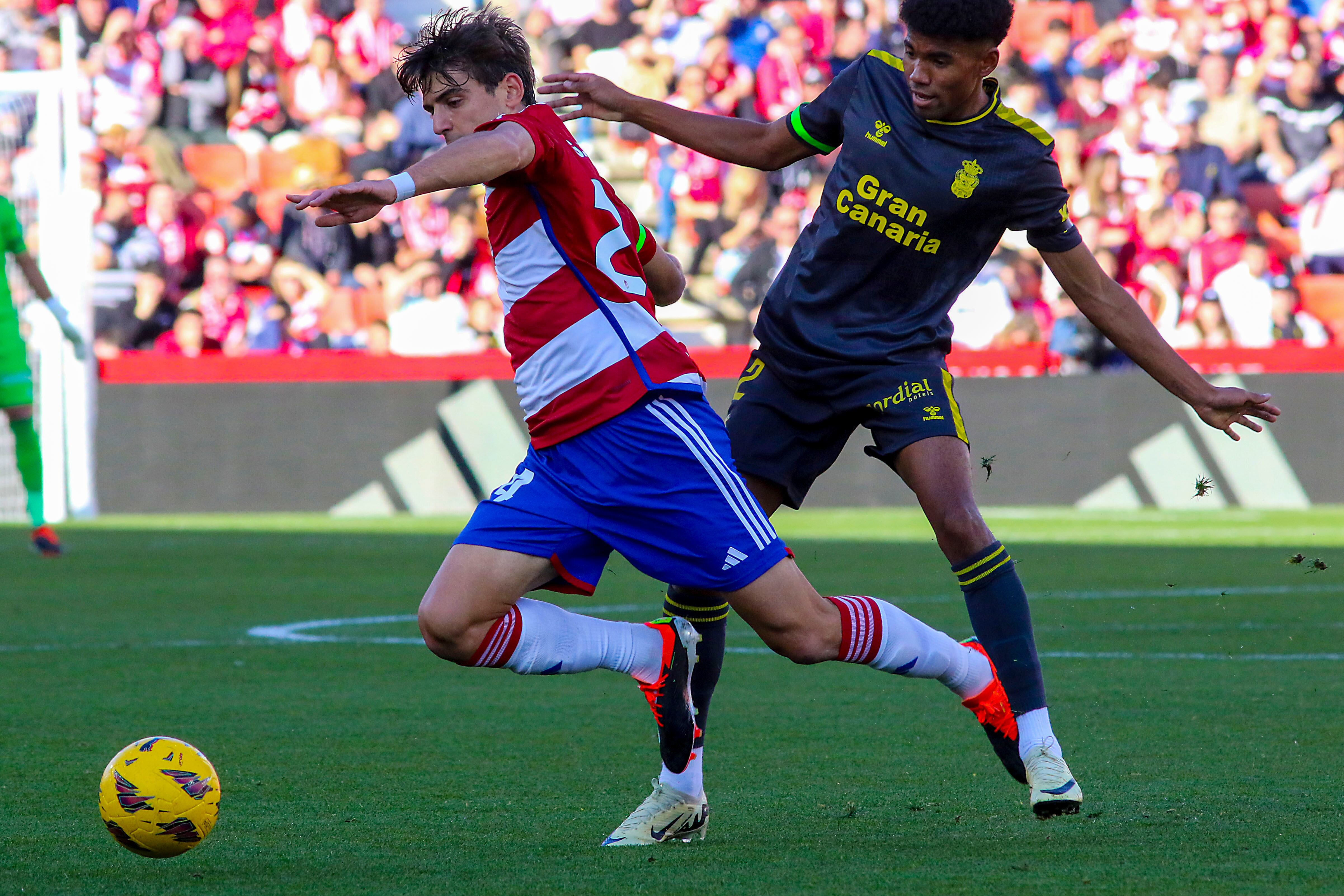 GRANADA, 03/02/2024.- El centrocampista del Granada Gonzalo Villar (i) pelea un balón con el defensa de la UD Las Palmas, Marvin Olawale durante el partido de LaLiga entre el Granada y la UD Las Palmas, este sábado en el Nuevo Estadio Los Cármenes. EFE/Pepe Torres.