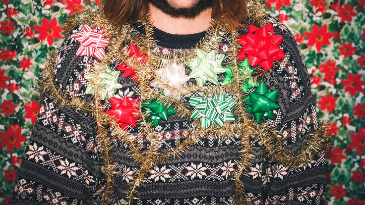 Una familia feliz pasea por las calles en navidad con cuernos de reno y pelucas de colores